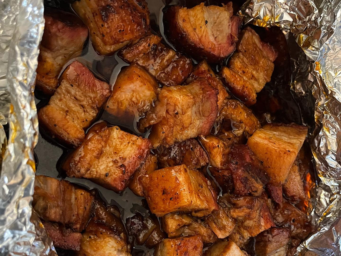 Burnt ends beef cubes in aluminum tray, casual catering presentation